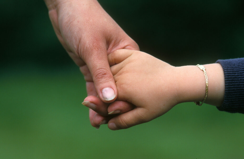 Enfant main dans la main de sa maman